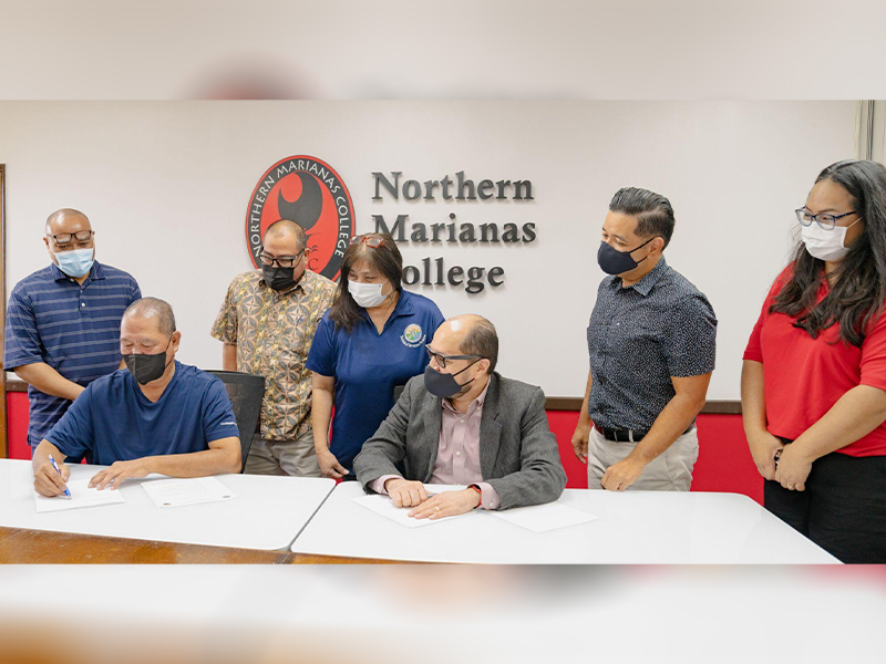Northern Marianas College has signed an agreement with the Department of Public Works to establish a federally funded on-the-job training and social support program.  In the picture are Department of Public Works Secretary James Ada, second left, signing the MOA as NMC President Galvin S. Deleon Guerrero, Vice President for Administration and Advancement Frankie Eliptico, second right, DPW and NMC staff look on Tuesday in the NMC administration conference room.