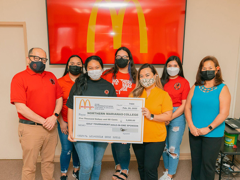 Northern Marianas College President Galvin Deleon Guerrero, EdD, left, poses with McDonald’s of Saipan and Guam vice president and owner/operator Marcia Ayuyu, right, executive assistant to the president Mable A. Glenn, and other NMC representatives at the McDonald's main office on Monday during the presentation of a check for $5,000 — McDonald’s hole-in-one prize donation to the  NMC Golf Open. Photo by James F. Sablan Jr.