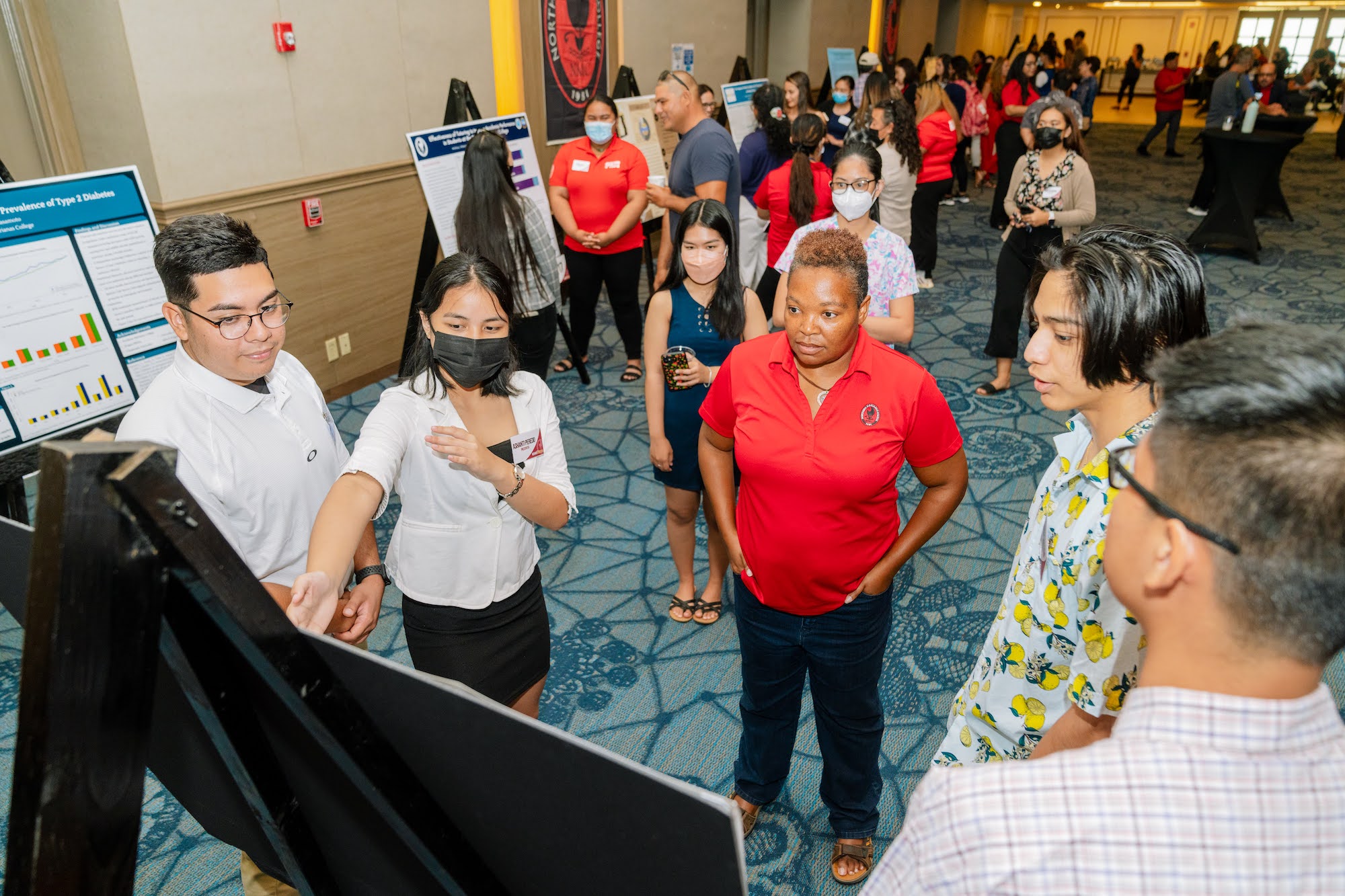 Northern Marianas College students Dimitri Sablan, Ashanti Peredo, Xue Qiu, Darlyn Ubarra, and Kiran Shrestha present their findings to audience members during NMC's 2nd Annual Research Symposium held at the Saipan World Resort on April 29, 2022