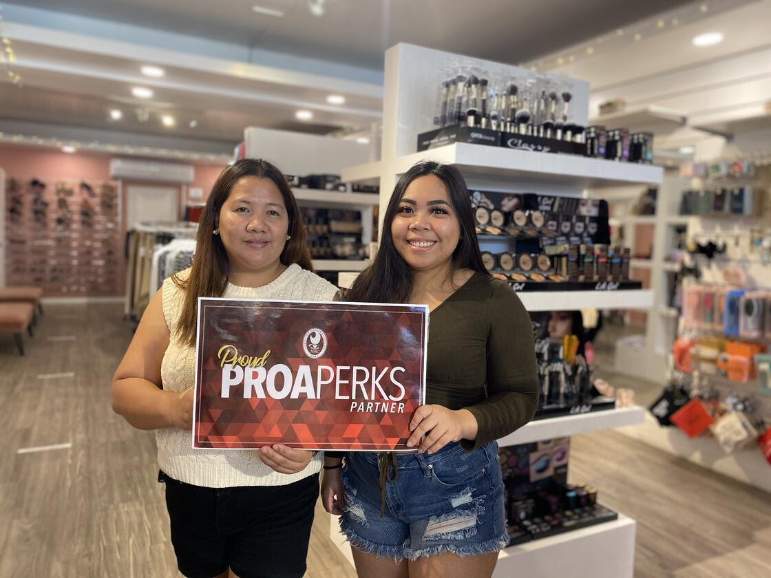 Two Women Holding a NMC Proud ProaPerks Partner Sign